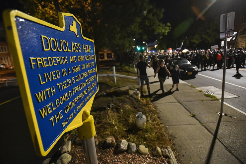 Demonstrators march past the site of abolitionist leader Frederick Douglass' home in Rochester, N.Y., Friday, Sept. 4, 2020, during a protest over the death of Daniel Prude. Prude apparently stopped breathing as police in Rochester were restraining him in March 2020 and died when he was taken off life support a week later. (AP Photo/Adrian Kraus)