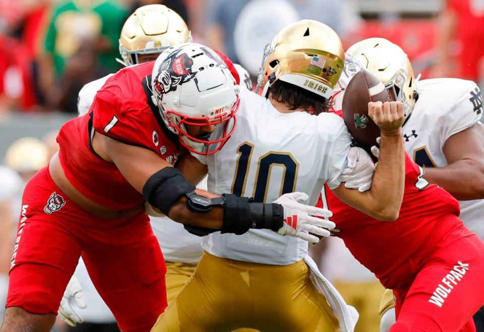 N.C. State defensive tackle Davin Vann (1) sacks Notre Dame quarterback Sam Hartman (10) causing him to fumble during the first half of N.C. State’s game against Notre Dame at Carter-Finley Stadium in Raleigh, N.C., Saturday, Sept. 9, 2023. Notre Dame recovered the fumble.