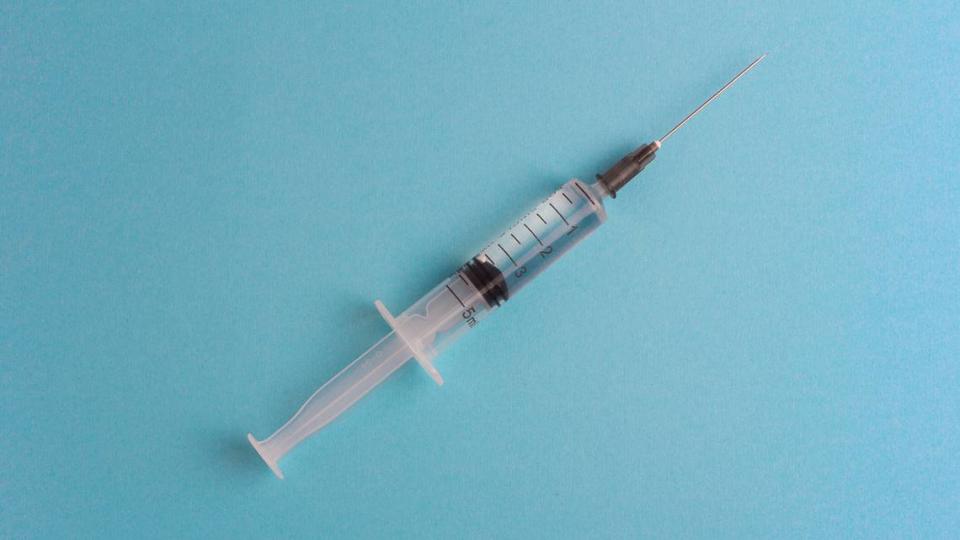 Medicine. Syringe with medication on blue background