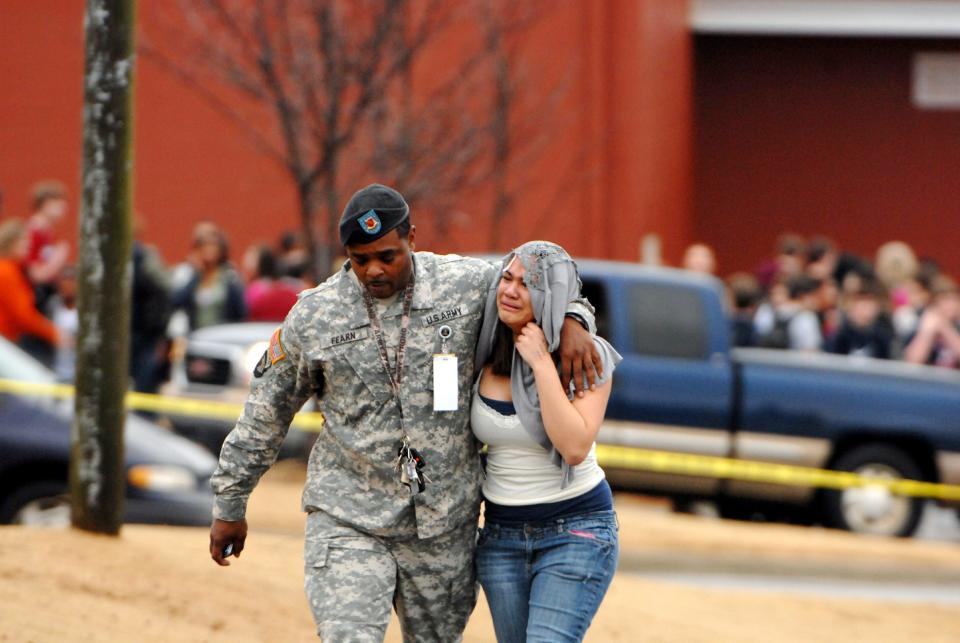 U.S. Army First Sgt. Robert Fearn escorts his daughter, Janelle Lawrence from Discovery Middle School in Madison, Ala., in 2010 after one student fatally shot another inside. Lawrence was standing next to the shooter when he pulled the trigger, and she said it sounded "like someone stepping on a balloon"