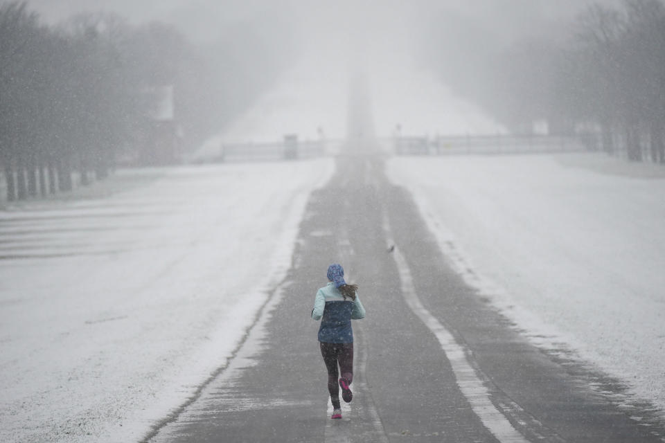 A jogger takes an early morning run in the snow at the Long Walk at Windsor Castle, Berkshire, Wednesday March 8, 2023. Parts of the UK wake up to snow and a yellow weather warning. (Yui Mok/PA via AP)