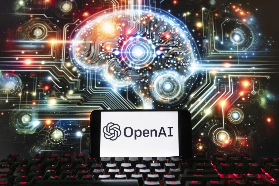 FILE - The OpenAI logo is displayed on a cell phone with an image on a computer screen generated by ChatGPT's Dall-E text-to-image model, Dec. 8, 2023, in Boston. European Union lawmakers are set to give final approval to the 27-nation bloc's artificial intelligence law Wednesday, putting the world-leading set of rules for the fast-developing technology on track to take effect later this year.(AP Photo/Michael Dwyer, File)