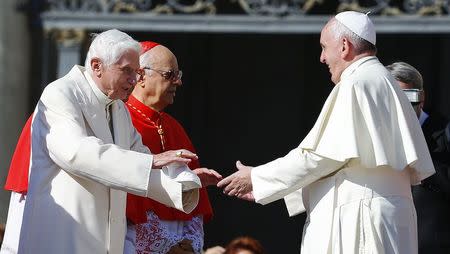 Pope Francis (R) greets Emeritus Pope Benedict XVI before a mass in Saint Peter's square at the Vatican September 28, 2014. REUTERS/Tony Gentile