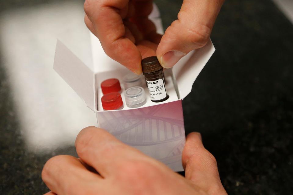 A Co-Diagnostics lab technician holds COVID-19 test components Friday, March 27, 2020, in Salt Lake City.