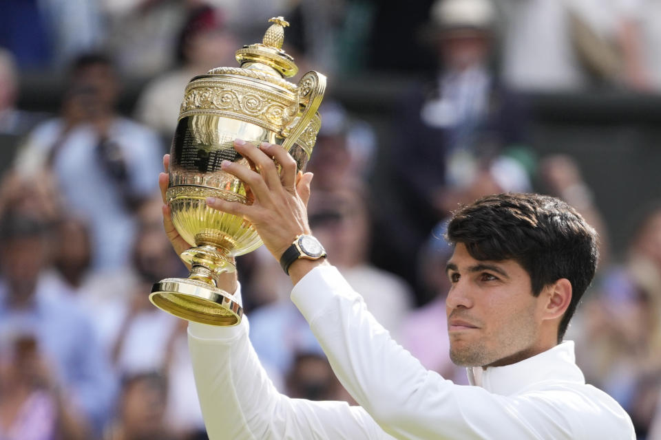 El español Carlos Alcaraz sostiene el trofeo al vencer en la final de Wimbledon a Novak Djokovic el domingo 14 de julio del 2024. (AP Foto/Kirsty Wigglesworth)