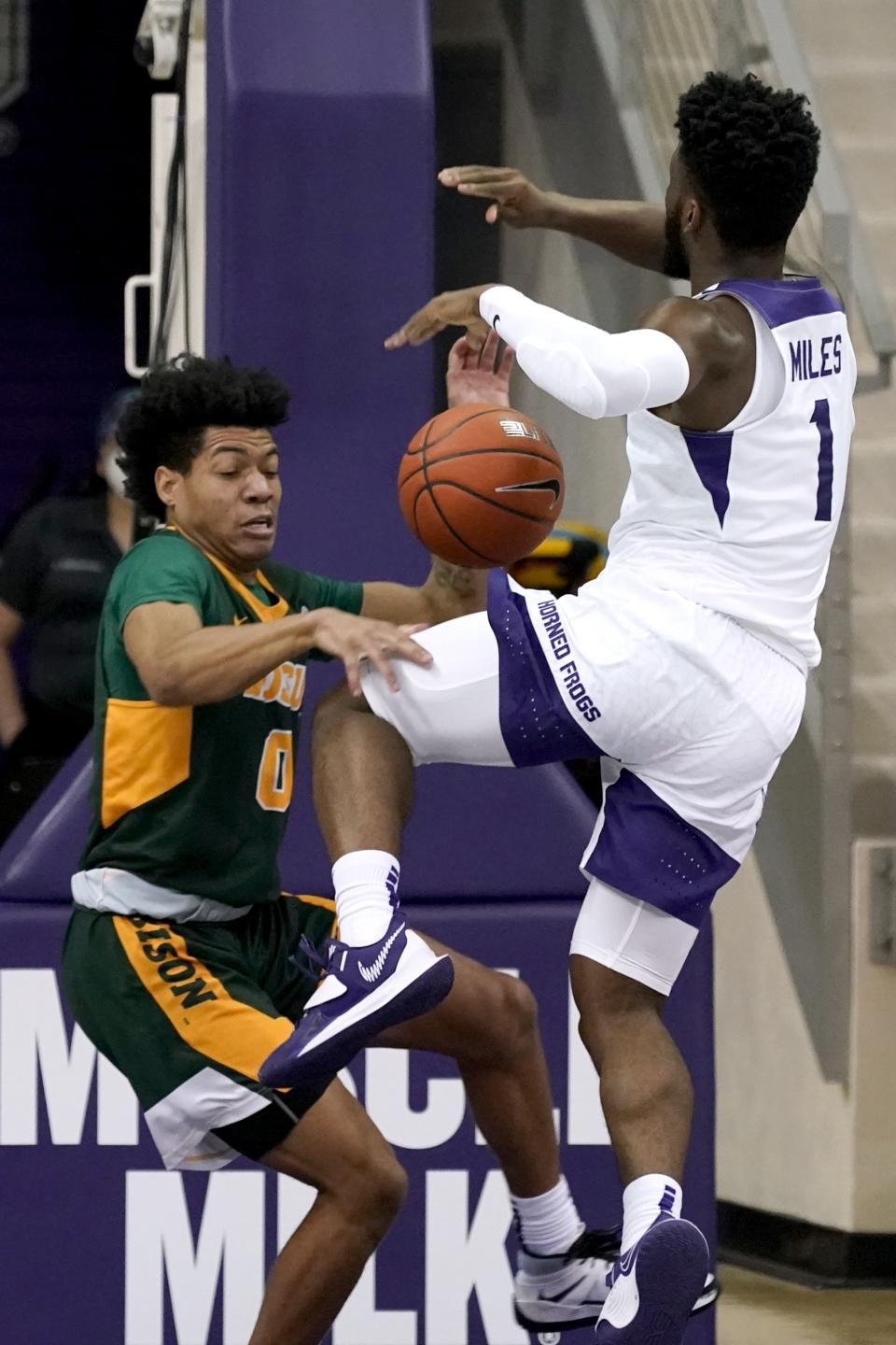 North Dakota State guard Dezmond McKinney (0) strips the ball away from TCU guard Mike Miles (1) as he drives to the basket for a shot in the first half of an NCAA college basketball game in Fort Worth, Texas, Tuesday, Dec. 22, 2020. (AP Photo/Tony Gutierrez)