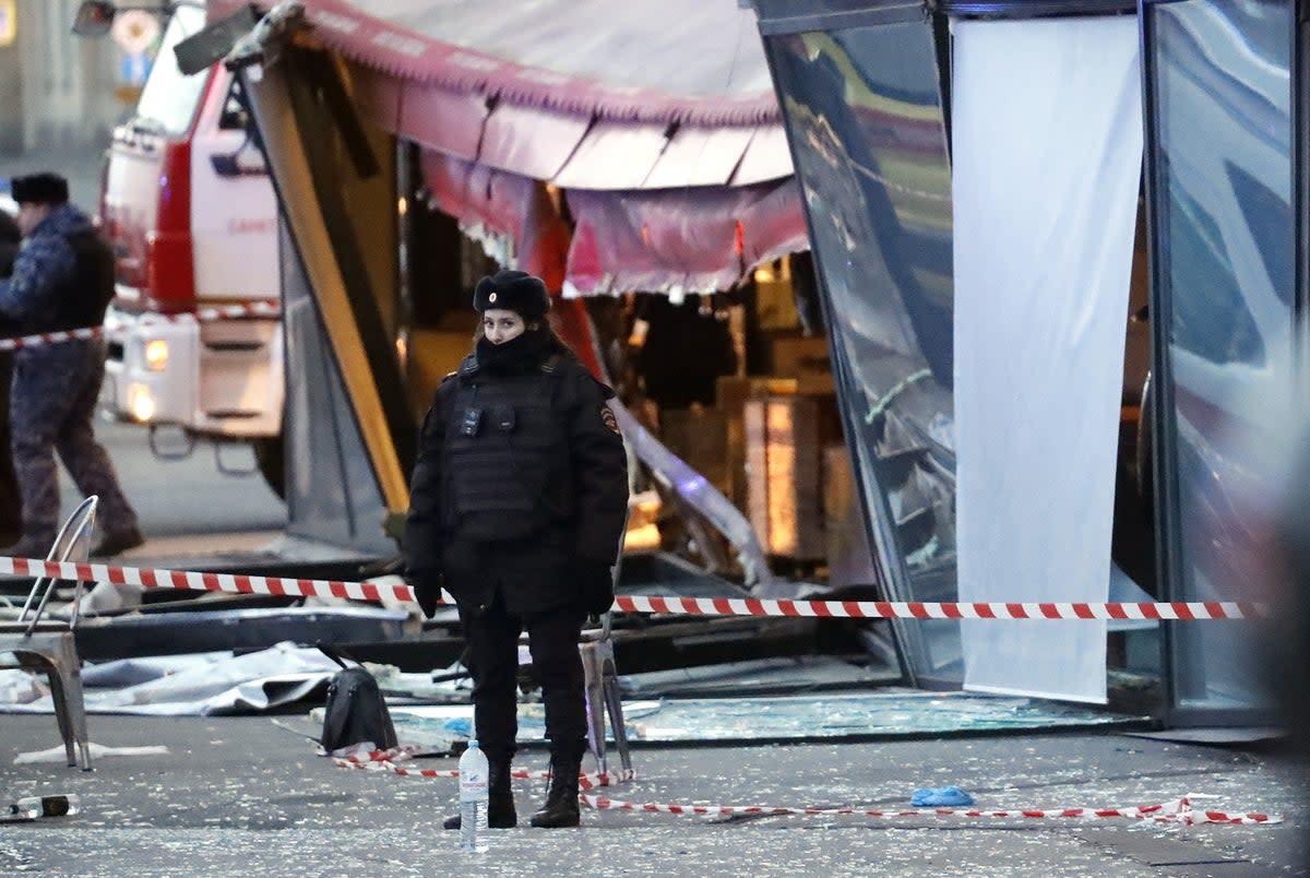 A police officer stands guard at the scene of an explosion at the cafe in St Petersburg, Russia (EPA)