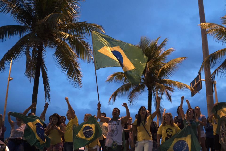 FILE - In this Sept. 29, 2018 file photo, people gather in front of the condominium where leading presidential candidate Jair Bolsonaro resides, to show their support after he was discharged from the hospital, in Rio de Janeiro, Brazil. Bolsonaro, who suffered intestinal damage and severe internal bleeding after the Sept. 6 attack at a campaign event and has undergone multiple surgeries, was discharged from a Sao Paulo hospital where he was being treated and returned to his home in Rio. (AP Photo/Leo Correa, File)