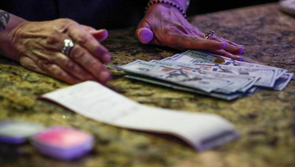 FILE - Money is counted on a counter at Oneida Casino in Green Bay in March 2020 after a woman won playing a slot machine. The state made a compact with the tribes to run gambling operations, which are regulated and provide $60 million in revenue to the state every year. However, it’s estimated 60,000 illegal gaming machines are operated in taverns across the state, resulting in millions of dollars of uncollected taxes.