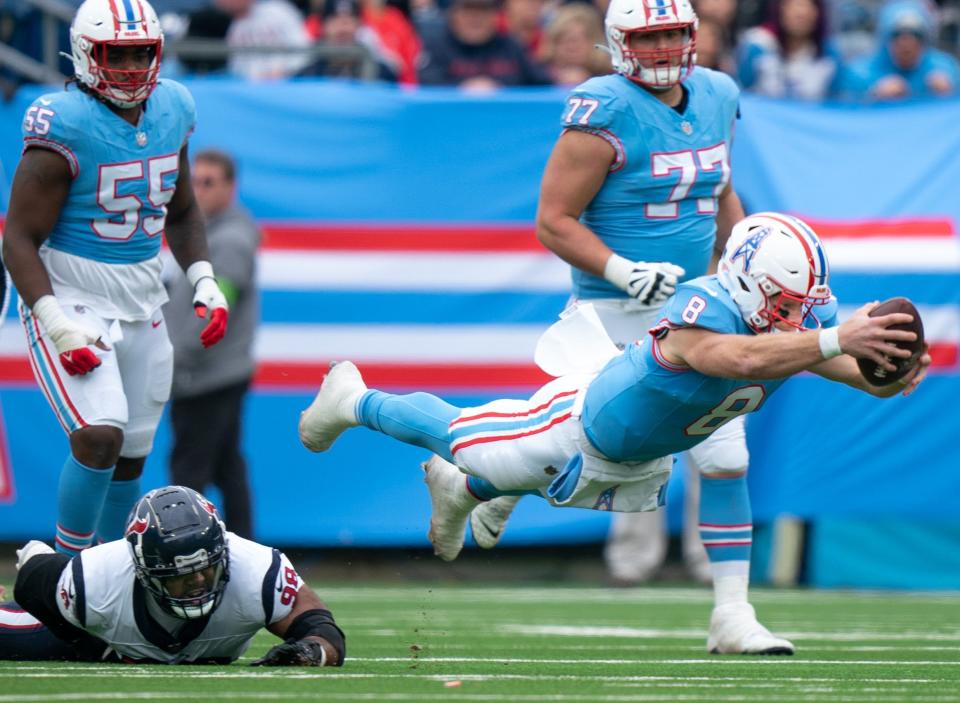 Tennessee Titans quarterback Will Levis (8) dives just short of a first down with Houston Texans defensive tackle Sheldon Rankins (98) tripping him up during their game at Nissan Stadium in Nashville, Tenn., Sunday, Dec. 17, 2023.