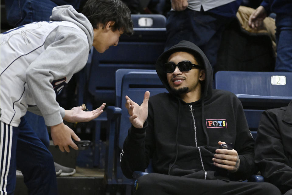 Charlotte Hornets player and former UConn Husky James Bouknight is greeted by a fan in the first half of an NCAA college basketball game between UConn against Seton Hall, Saturday, Feb. 18, 2023, in Storrs, Conn. (AP Photo/Jessica Hill)