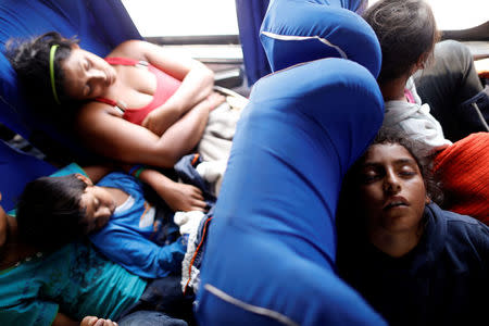 Children sleep while riding on a bus with fellow Central American migrants, as part of a caravan moving through Mexico toward the U.S. border, on a highway in Puebla state, Mexico April 6, 2018. REUTERS/Edgard Garrido