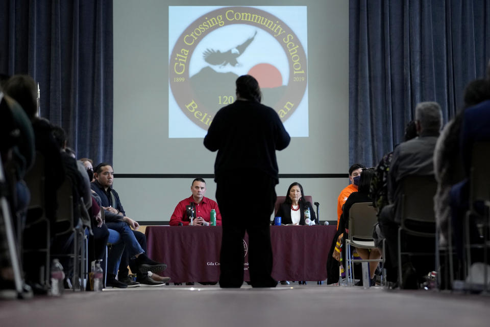 U.S. Interior Secretary Deb Haaland, right, and Assistant Secretary for Indian Affairs Bryan Newland, left, listen as April Hiosik Ignacio, center, speaks of her grandmother's time in an Indian boarding school during a "Road to Healing" event, Friday, Jan. 20, 2023, at the Gila Crossing Community School in Laveen, Ariz. The "The Road to Healing," is a year-long tour across the country to provide Indigenous survivors of the federal Indian boarding school system and their descendants an opportunity to share their experiences. (AP Photo/Matt York)