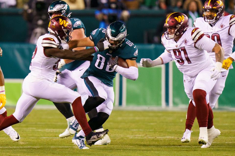 Washington Commanders linebacker Jamin Davis (52) gets his hand in Philadelphia Eagles tight end Dallas Goedert (88) helmet as Goedert runs with the ball during the NFL football game, Monday, Nov. 14, 2022, in Philadelphia.