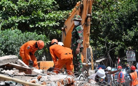 Members of an Indonesian search and rescue team look for victim of the recent quake in Tanjung on Lombok island on August 9 - Credit: ADEK BERRY/AFP