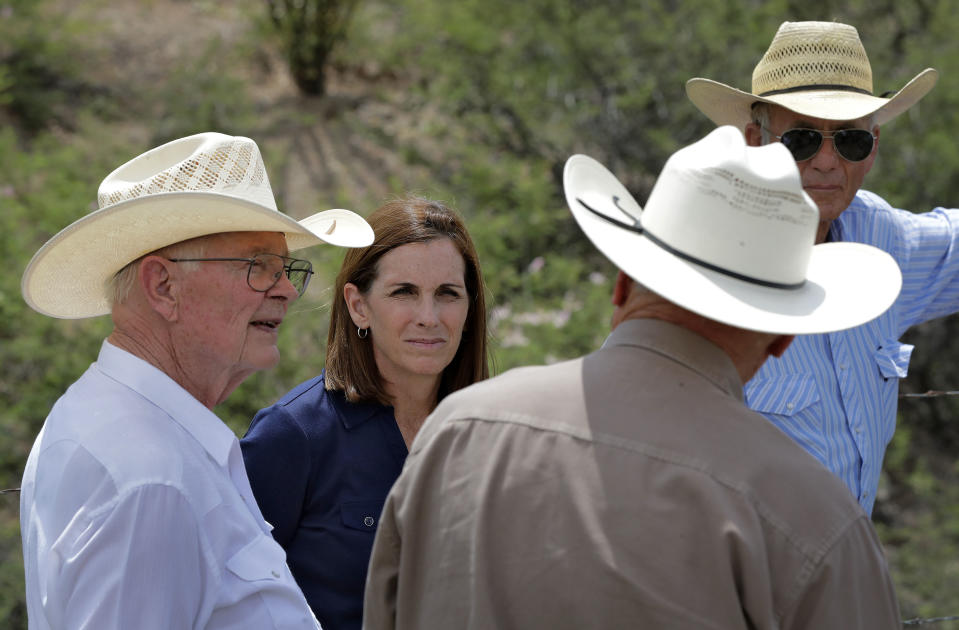 In this Wednesday, Aug. 22, 2018 photo, U.S. Senatorial candidate U.S. Rep. Martha McSally, R-Ariz., stands at the international border with Mexico, with ranchers Jim Chilton, left, Ted Noon, center, and Tom Kay, right, south of Arivaca, Ariz. In her bid to become the Republican Senate nominee, McSally has tacked hard right after initially keeping her distance from President Donald Trump. (AP Photo/Matt York)