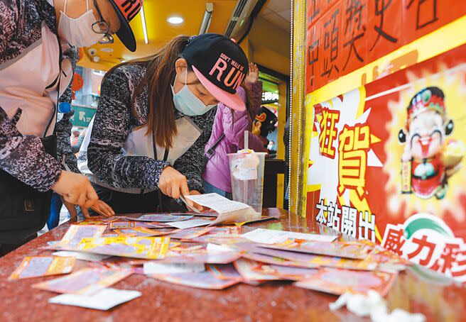 不少民眾過年習慣買彩券，彩券行桌上滿是刮刮樂的廢棄彩券。（季志翔攝）