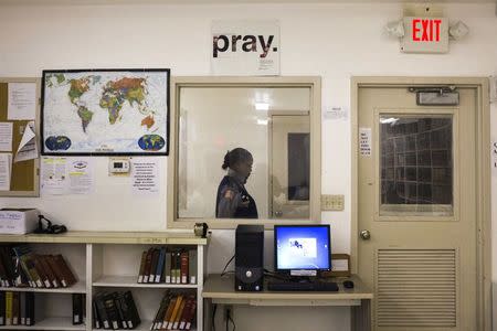 A security official walks past a sign seen inside a Southwestern Baptist Theological Seminary library located in the Darrington Unit of the Texas Department of Criminal Justice men's prison in Rosharon, Texas August 12, 2014. REUTERS/Adrees Latif