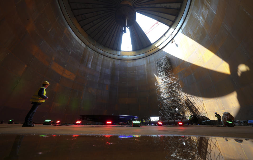 Journalists are seen inside a vast thermal tank to store hot water in Berlin, Germany, Thursday, June 30, 2022. Power provider Vattenfall unveiled a new facility in Berlin on Thursday that turns solar and wind energy into heat, which can be stored in a vast thermal tank and released into the German capital's grid as needed, smoothing out the fluctuating supply problem of renewables. (AP Photo/Michael Sohn)