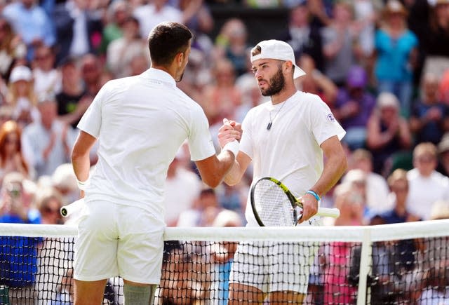 Jacob Fearnley shakes hands with Novak Djokovic