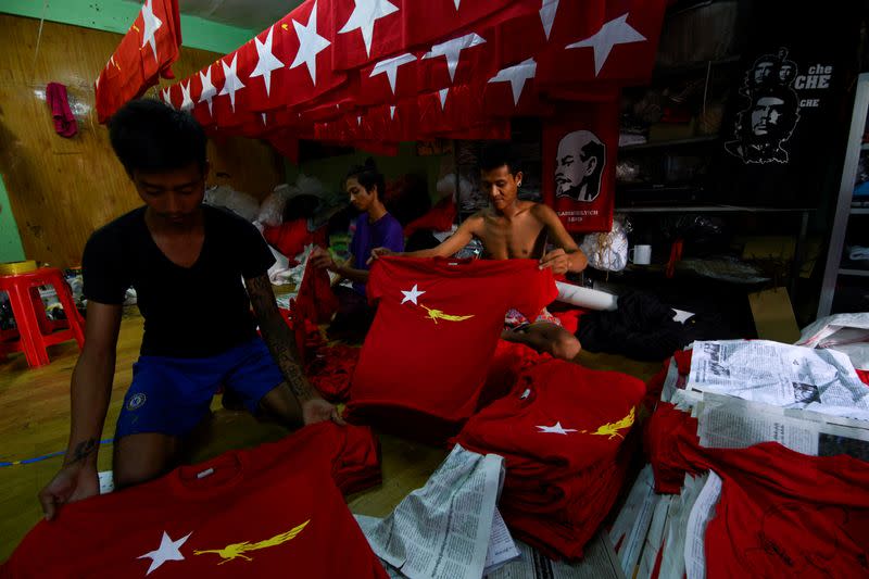 Workers prepare t-shirts with the logo of Aung San Suu Kyi's National League for Democracy NLD party in Yangon