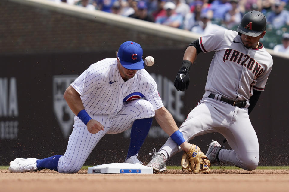 Arizona Diamondbacks' Eduardo Escobar, right, slides safely into second base after hitting a double as Chicago Cubs second baseman Nico Hoerner misses the catch during the first inning of a baseball game in Chicago, Saturday, July 24, 2021. (AP Photo/Nam Y. Huh)