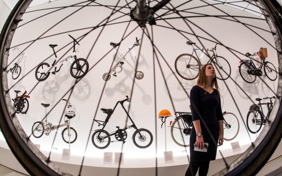 Design Museum curator Eleanor Suggett looking at bikes of the future exhibited on the walls, including a Sir Clive Sinclair designed "X-Bike" - Credit: Julian Andrews/Eye R8 Productions