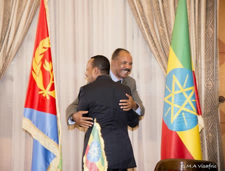 FILE PHOTO: Ethiopia's Prime Minister Abiy Ahmed and Eritrean President Isaias Afwerki embrace at the declaration signing in Asmara, Eritrea July 9, 2018 in this photo obtained from social media on July 10, 2018. GHIDEON MUSA ARON VISAFRIC/via REUTERS