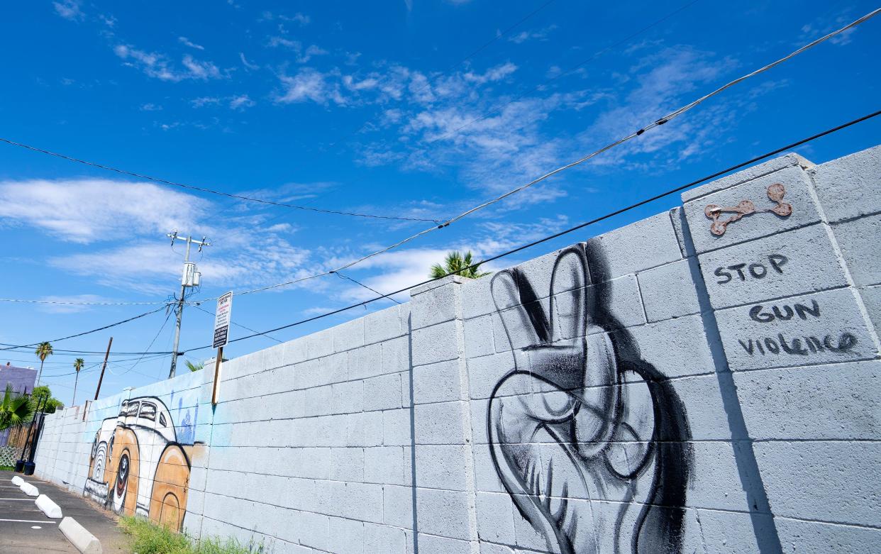 The new murals on Roosevelt Row, pictured on Aug. 11, 2022, depict hands making the peace sign "to focus on the human aspect for solutions to gun violence as opposed to the guns that do not shoot by themselves," artist Kyle Holbrook said.