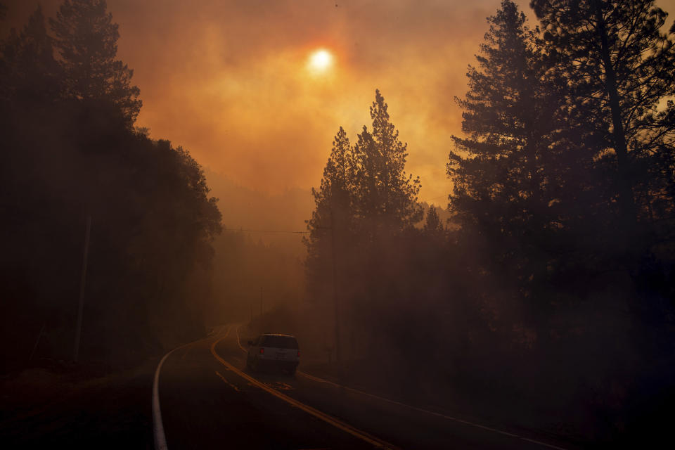 A vehicle drives through smoke from a wildfire near Pulga, Calif., Sunday, Nov. 11, 2018. (AP Photo/Noah Berger, File)