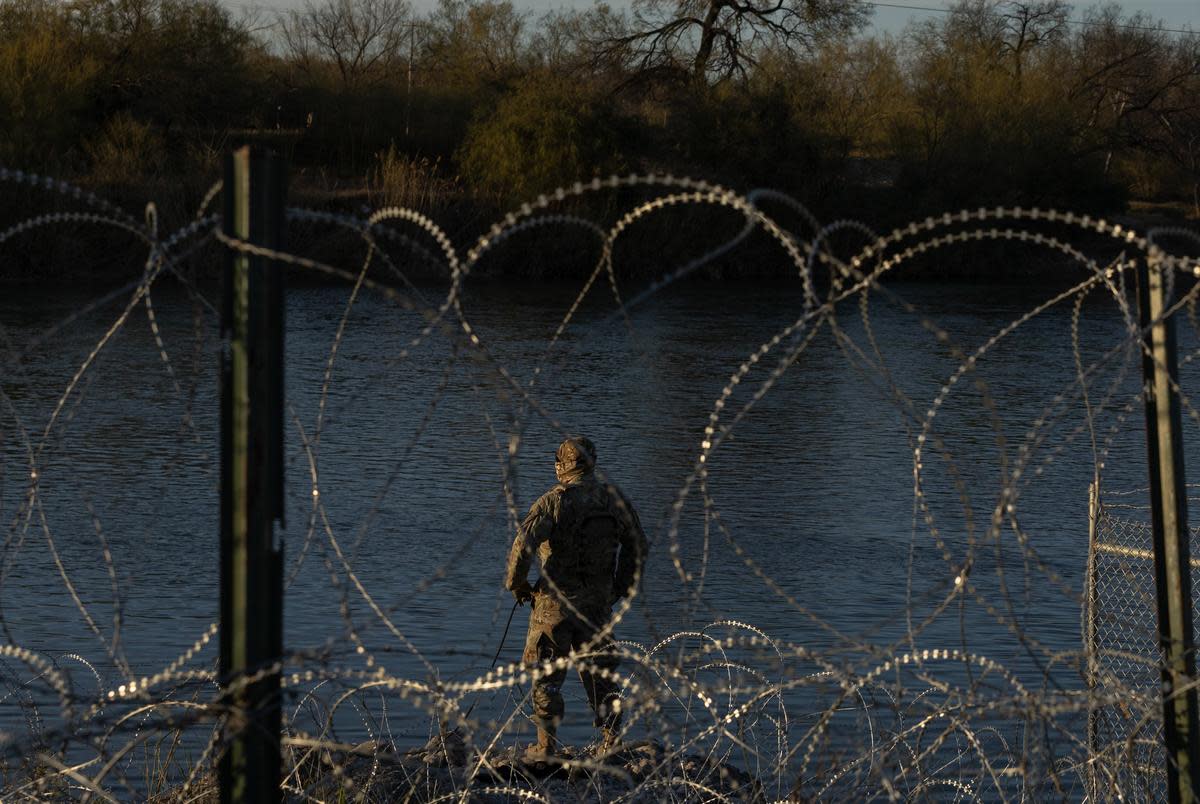 A Texas National Guard member at the bank of the Rio Grand at Shelby Park in Eagle Pass, on Jan. 16, 2024. Texas has closed off Shelby Park, cutting access to federal agents to part of the Texas-Mexico border and escalating tensions between the Biden administration and Gov. Greg Abbott.