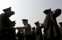 A Chinese army advisor (C) puts rank on Cambodian army graduates during a graduation ceremony at Army Institute in Kampong Speu province March 12, 2015. REUTERS/Samrang Pring