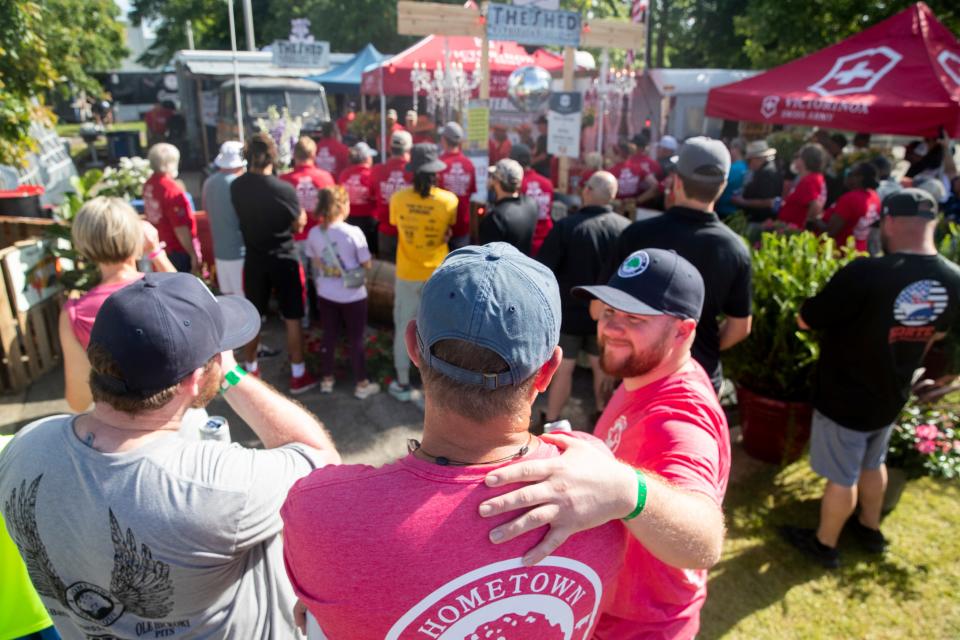 Dustey Walley with Hometown BBQ watches friends in The Shed BBQ team compete in the whole hog division finals as his son Connor Walley, right, puts his arm around him and Connor’s twin brother, Benjamin Walley, left, watches as well during the Memphis in May World Championship Barbecue Cooking Contest on May 18, 2024, at Liberty Park in Memphis. After the team found out it had not made finals, Walley and Scott Guy walked over to offer any help they could to their friends in The Shed BBQ team, who were in the final three teams. “Every one in the barbecue community looks out for one another,” Hometown BBQ team member Brian Grant said earlier in the competition.