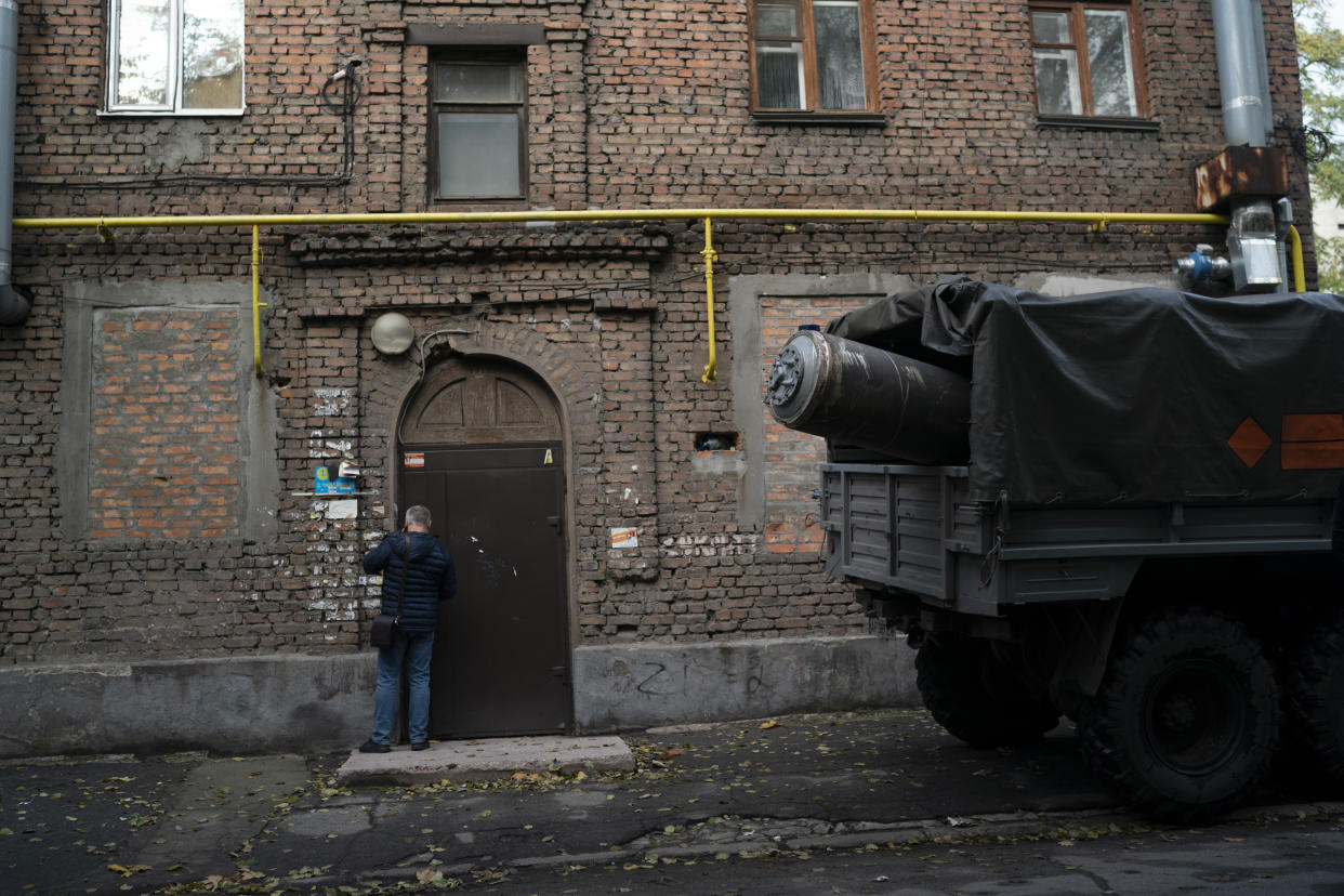 A man stands next to a truck that carries the remains of a missile after a Russian attack in Zaporizhzhia, Ukraine, Friday, Oct. 21, 2022. (AP Photo/Leo Correa)