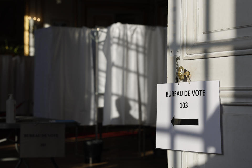 A person is shadowed on a voting booth in a polling station Sunday, June 19, 2022 in Bischeim, outside Strasbourg, eastern France. French voters are going to the polls in the final round of key parliamentary elections that will demonstrate how much legroom President Emmanuel Macron's party will be given to implement his ambitious domestic agenda. (AP Photo/Jean-Francois Badias)