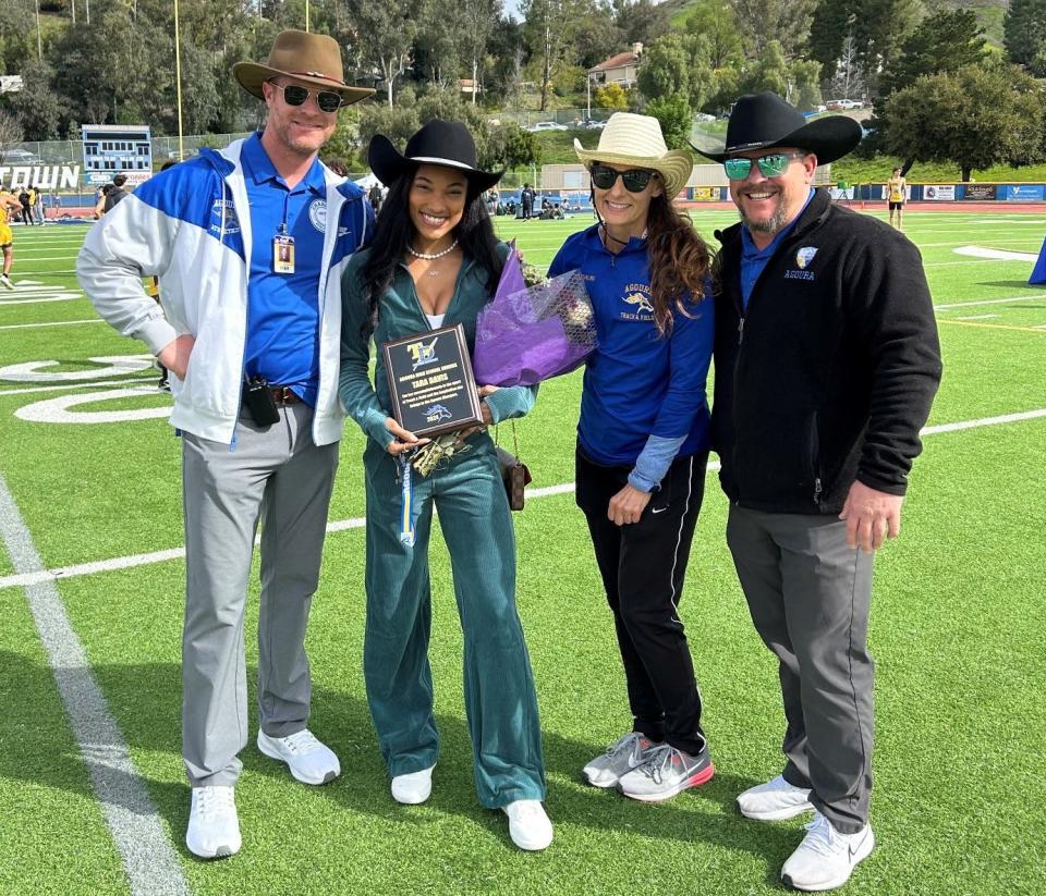 Agoura High graduate Tara Davis, with Agoura principal Garrett Lepisto (far left), track coach Amanda Starling and athletic director Clint Cummings, poses with a plaque honoring her accomplishments in track during the first annual Tara Davis Invitational at Agoura High on Saturday.