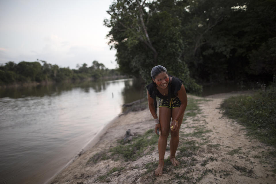 In this Sept. 3, 2019 photo, a woman washes with soap at the Gurupi River after a meeting of Tembé tribes at the Tekohaw indigenous reserve, Para state, Brazil. About 600 members of the Tembé tribe live in Tekohaw. It’s located on the banks of the Gurupi River where many fish for piranhas and other fish that they later grill over wood fires. (AP Photo/Rodrigo Abd)