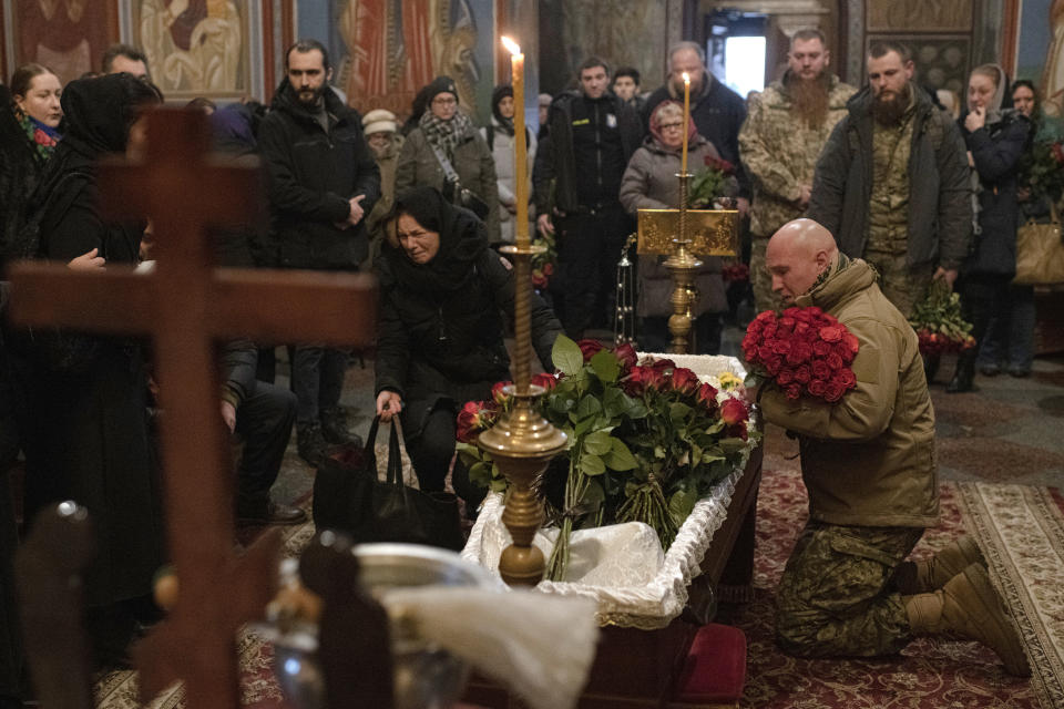 Relatives, friends, and comrades mourn next to the coffin of Ukrainian serviceman Sergii Myronov, killed fighting Russian troops in Donetsk region, during a funeral ceremony at St. Michael's Golden-Domed Monastery in Kyiv, Ukraine, Wednesday, Nov. 23, 2022. (AP Photo/Andrew Kravchenko)