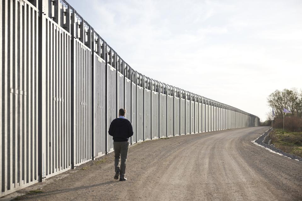In this photo provided by the Greek Prime Minister's Office, Greece's Prime Minister Kyriakos Mitsotakis walks next to a border wall near the town of Feres, along the Evros River which forms the frontier between Greece and Turkey, on Friday, March 31, 2023. Mitsotakis promised Friday to extend a wall across all of the country's land border with Turkey as he campaigned for the country's general election. (Dimitris Papamitsos/Greek Prime Minister's Office via AP)