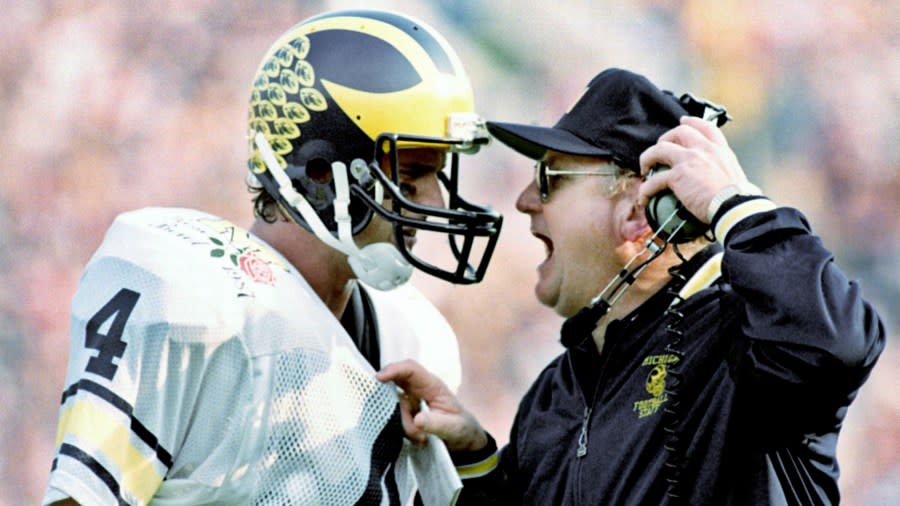 Bo Schembechler pulls his headset away while yelling to communicate with his quarterback, Jim Harbaugh.