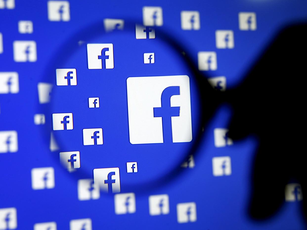 FILE PHOTO: A man poses with a magnifier in front of a Facebook logo on display in this illustration taken in Sarajevo, Bosnia and Herzegovina, December 16, 2015.   REUTERS/Dado Ruvic/Illustration