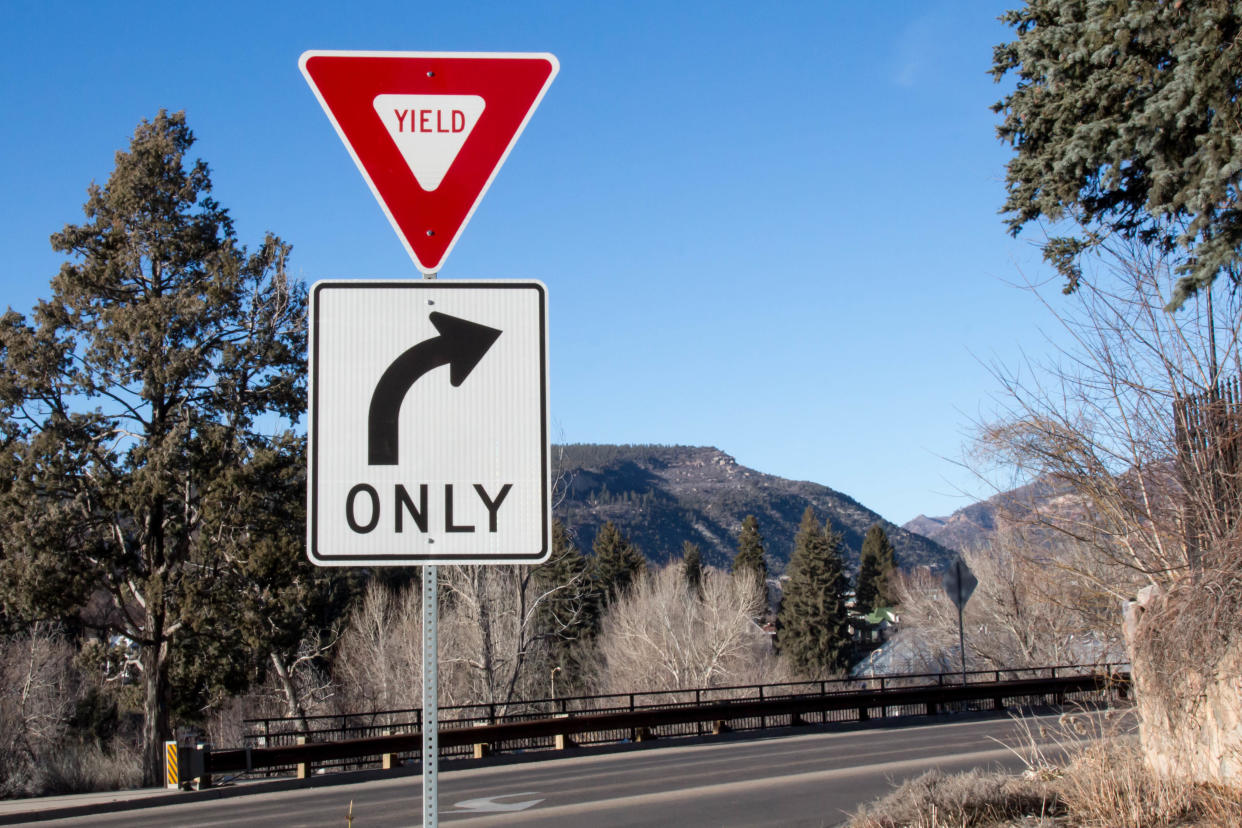 Red and white triangular yield and rectangular right curve only signs