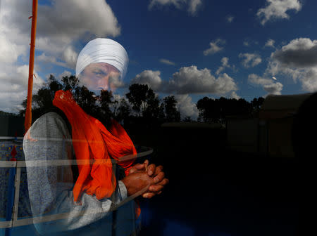 FILE PHOTO: A Sikh migrant worker looks through a window of the temple in Borgo Hermada, in the Pontine Marshes, south of Rome. Originally from India’s Punjab state, the migrant workers pick fruit and vegetables for up to 13 hours a day for between 3-5 euros ($3.30-$5.50) an hour, in Bella Farnia, Italy May 19, 2019. REUTERS/Yara Nardi