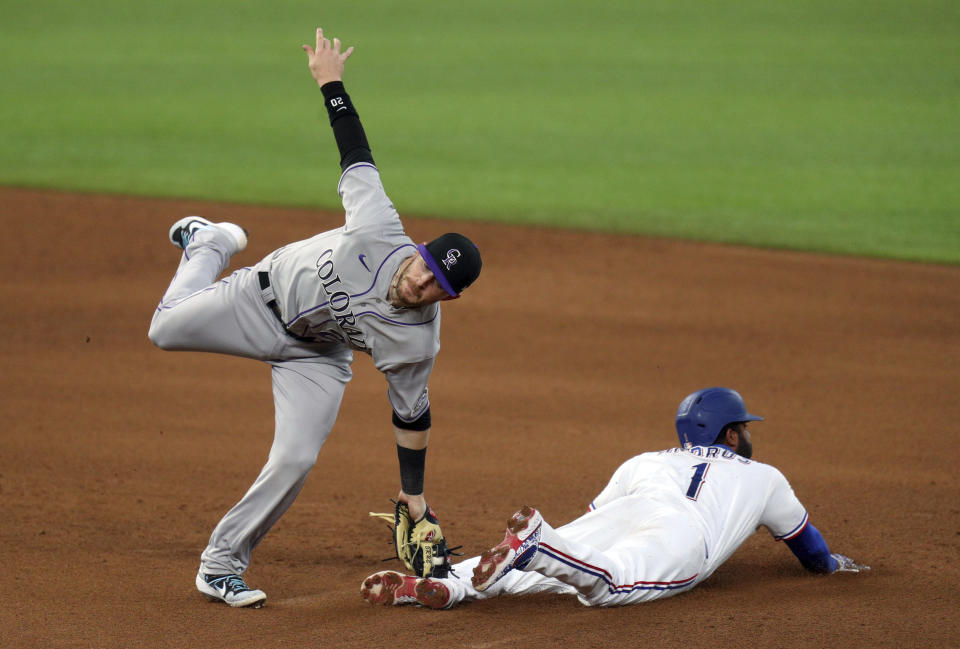 Colorado Rockies shortstop Trevor Story (27) makes the tag on Texas Rangers' Elvis Andrus (1) who was attempting to steal in the fourth inning of a baseball game Saturday, July 25, 2020, in Arlington, Texas. (AP Photo/Richard W. Rodriguez)