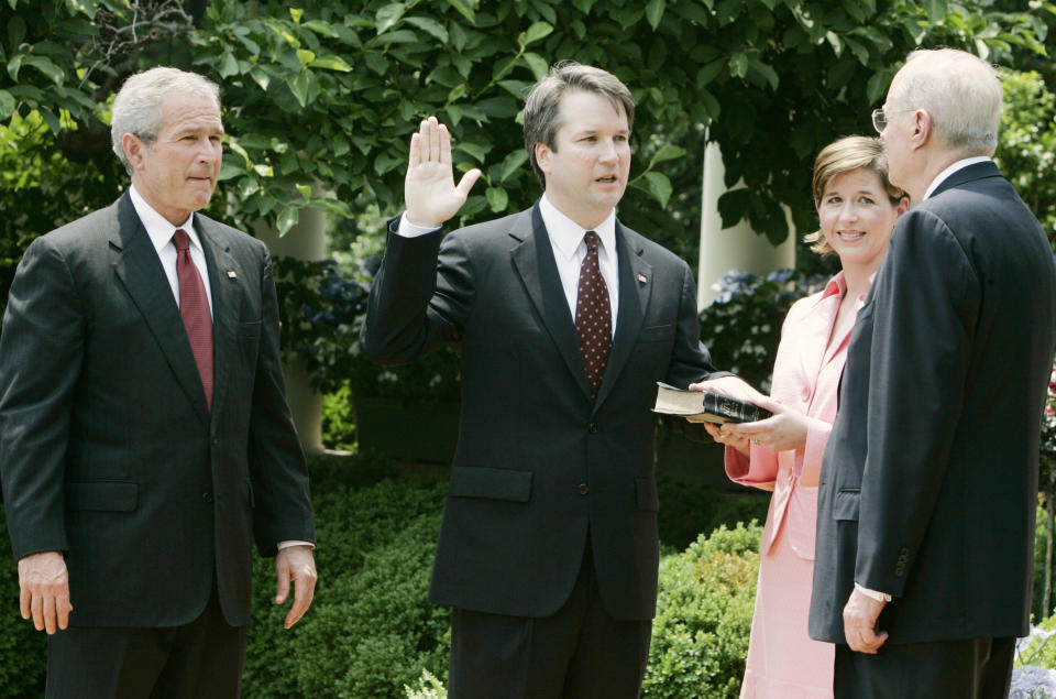 (From left) President George W. Bush, Brett Kavanaugh and his wife, Ashley Estes Kavanaugh, at his swearing-in as a judge for the U.S. Court of Appeals for the District of Columbia by Justice Anthony Kennedy at the White House in 2006. (Photo: Larry Downing / Reuters)