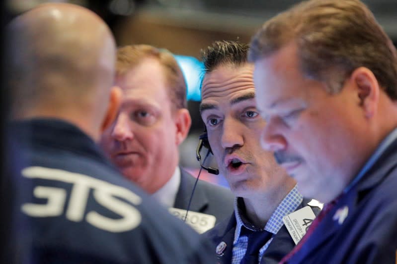 FILE PHOTO: Traders work on the floor at the NYSE in New York