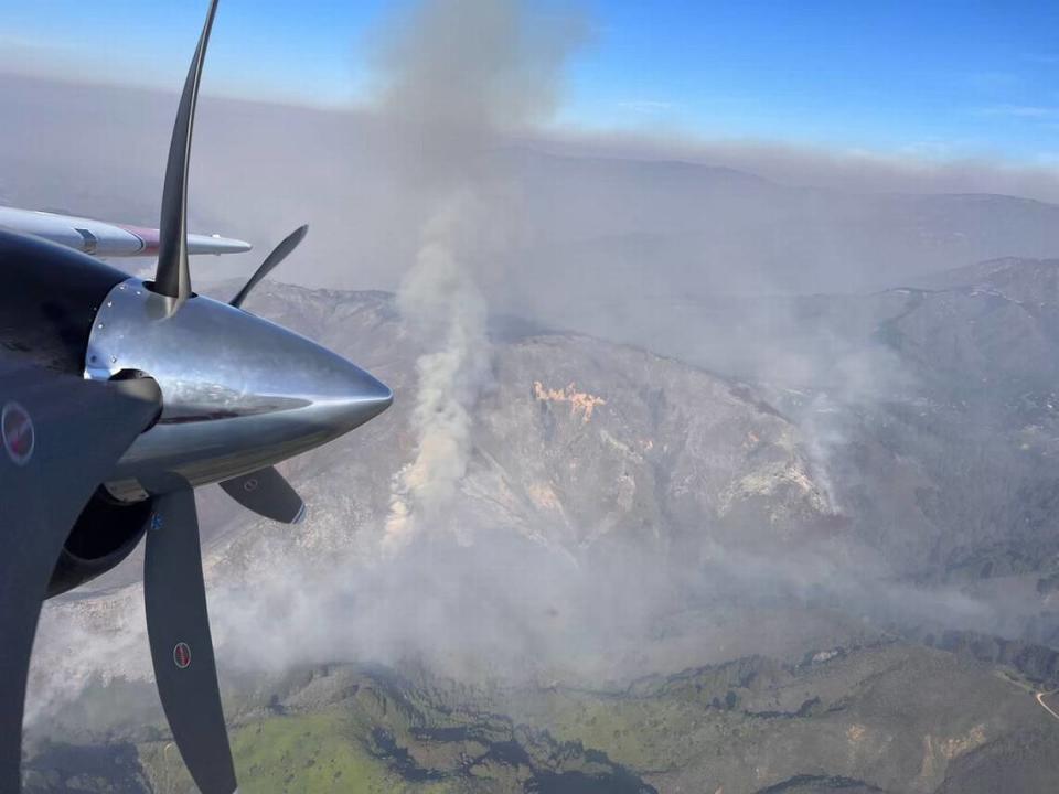 A plane flies over the Colorado Fire in Big Sur.