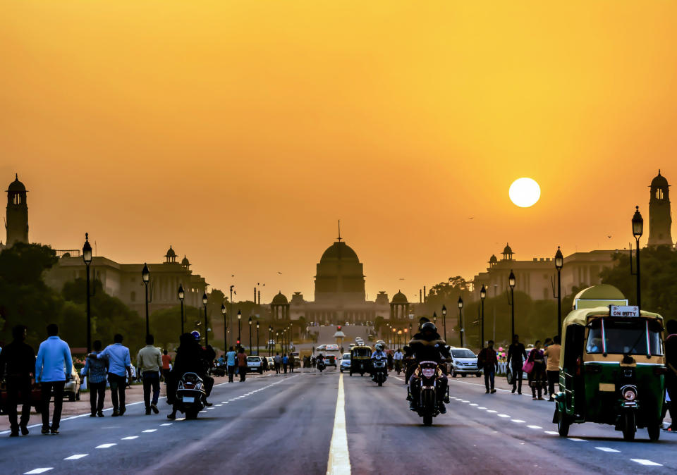 A busy street in India during sunset.
