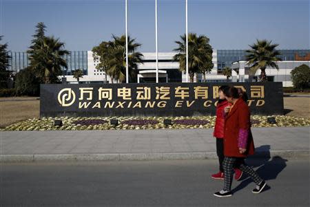 People walk past outside a Wanxiang electric vehicle factory in Hangzhou, Zhejiang province, January 22, 2014. REUTERS/Aly Song