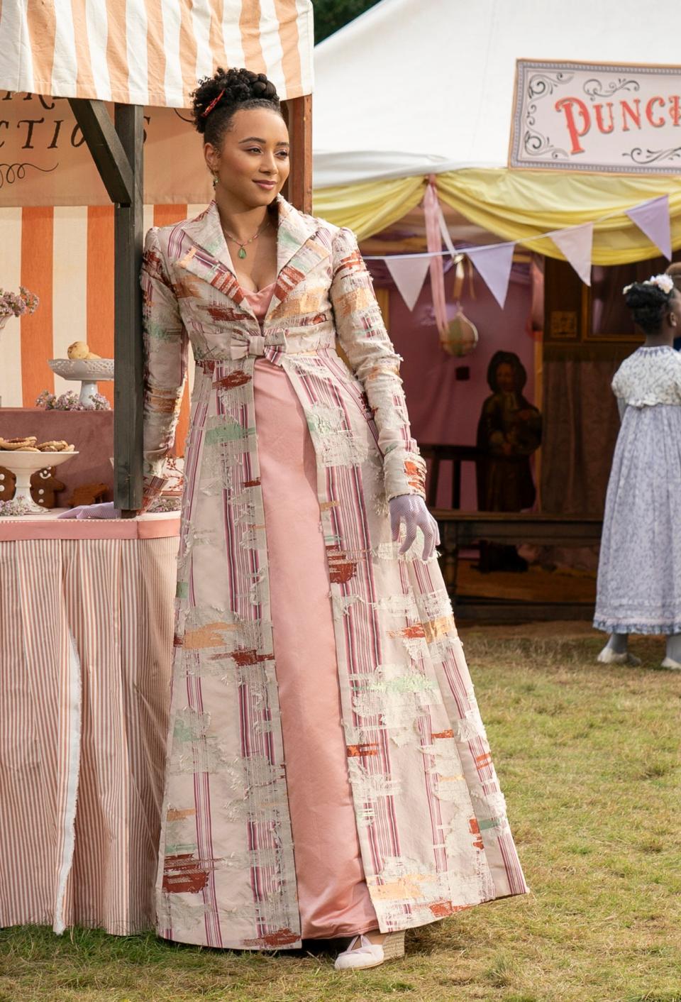 at a festival, Alice in a Victorian-style dress with a striped pattern and structured shoulders and neckline